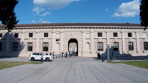 Mantova, Italy - 30 05 2021: Main entrance of the famous Palazzo Te in Mantua.
Wide facade of the historic building with tourists queuing to enter the museum. Renaissance style and architecture.