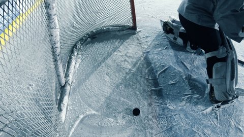 Inside Ice Hockey Goals Net Hit by Puck. Perfect Shot Missed by Goalie Resulting in a Missed Goal. Documentary Style Cinematic Shot with Dramatic Raw Lighting.