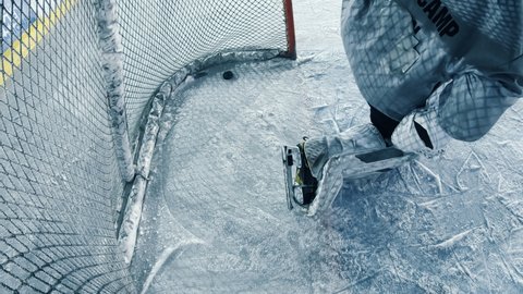 Inside Ice Hockey Goals Net Hit by Puck. Perfect Shot Missed by Goalie Resulting in a Missed Goal. Documentary Style Cinematic Shot with Dramatic Raw Lighting.