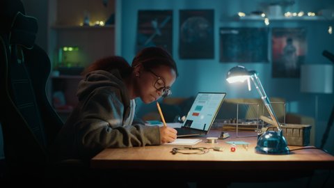 Young Teenage Multiethnic Schoolgirl is Studying Science Topic About Robotics at Home. Girl is Working on Homework for School. Young Female Reading Research Articles About Her Hobby. Education Concept