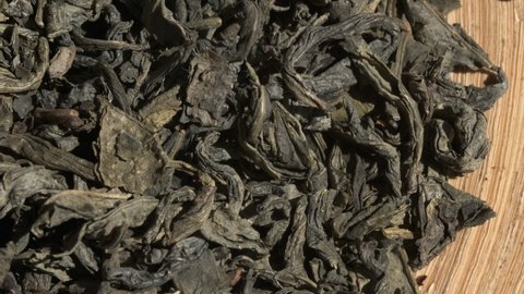 Green Chinese tea gunpowder. Dried coiled leaves close up. Rotation. Macro video. Selective focus