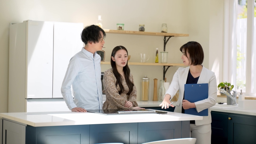 asian couple talking to real estate sales person