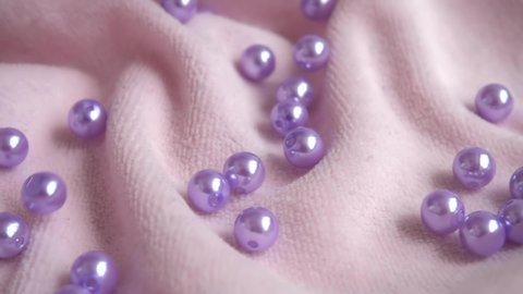 Pearls falling on the fabric. Slow motion.	