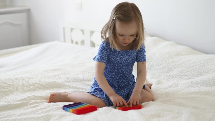 Adorable little girl playing with pop it fidget