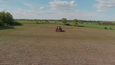 Farmer Spraying Herbicide on young corn plants in a field in Nebraska, USA-1