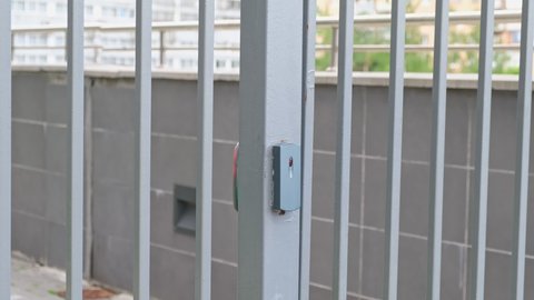 Male using intercom at residential building entrance. opens electronic code lock. man hand entering security system code, pressing button with index finger intercom device entrence door.