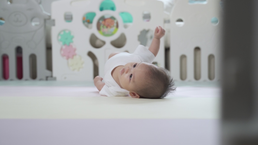 asian baby infant learning fliping and crawling in baby playpen at home. authentic life at home. baby practice crawl lesson in playpen. happy baby infant development skill improving of 5 months. Royalty-Free Stock Footage #1073674265