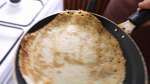Woman cooking pancakes on frying pan on Maslenitsa