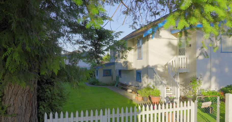 Establishing shot. Entrance of old house with stair steps, green trees and nice landscape in Vancouver, Canada, North America. Day time on June 2021. Still camera view.