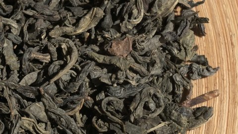 Green Chinese tea gunpowder. Dried coiled leaves close up. Rotation. Macro video. Selective focus