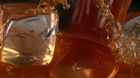 Super Slow Motion Detail Shot of Pouring Ice Coffee into Glass with Ice Cubes at 1000 fps.