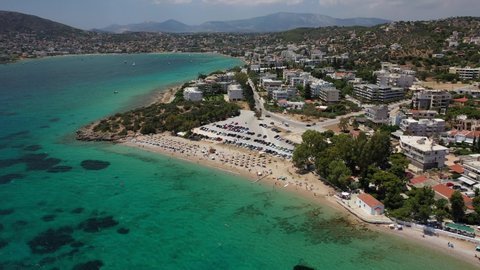 Aerial drone video of popular to Athenians close to Athens beach of Agios Spyridonas with small chapel by the sea, Porto Rafti, Attica, Greece