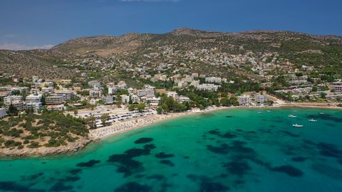 Aerial drone video of popular to Athenians close to Athens beach of Agios Spyridonas with small chapel by the sea, Porto Rafti, Attica, Greece
