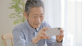 Senior man watching videos on smartphone