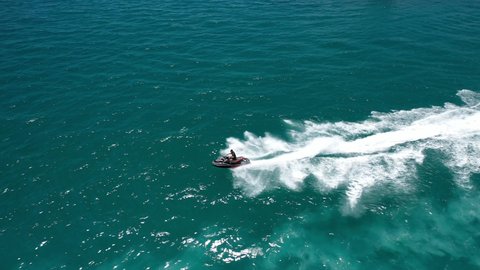 Aerial drone video of jet ski watercraft cruising in high speed in tropical exotic island