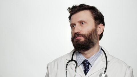 Skeptic doctor, sarcasm emotion. Dissatisfied man doctor on white background looking at camera expressing skeptical attitude and discontent with his look
