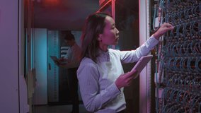 Slowmo tracking shot of female Asian data center technician using tablet and checking computing equipment with cables in server room - Powered by Shutterstock - Get 15% off with code: PIKWIZARD15