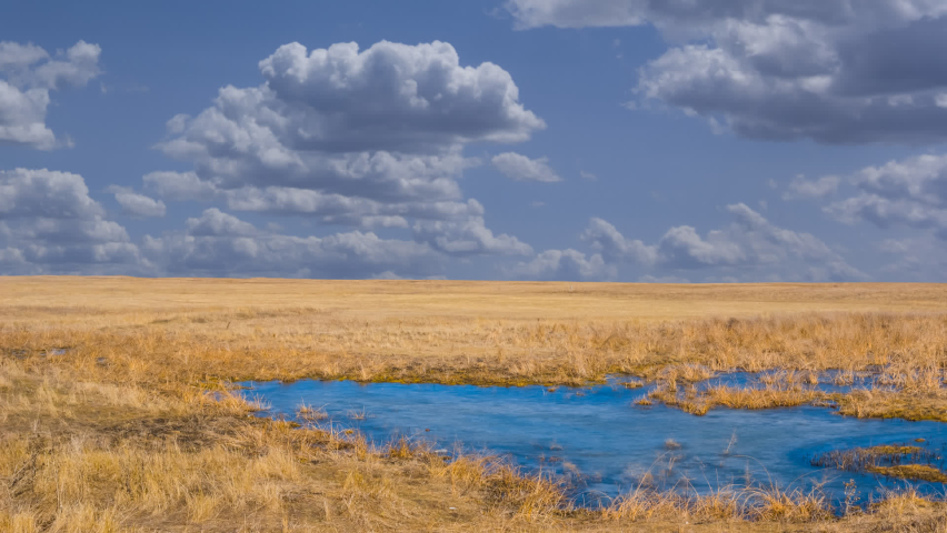 prairie with small blue lake time lapse scene