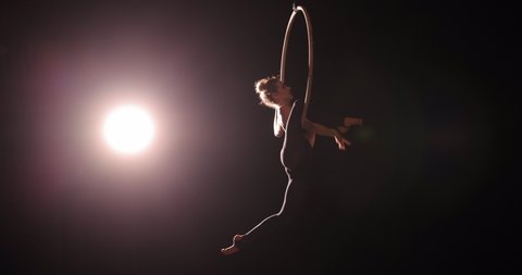 Girl gymnast hanging on the acrobatic ring making an performance show