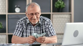 Happy 70s grandfather counting cash money dollars enjoying financial independence at workplace. Smiling elderly man checking currency bills savings lottery win retirement household expenses planning - Powered by Shutterstock - Get 15% off with code: PIKWIZARD15