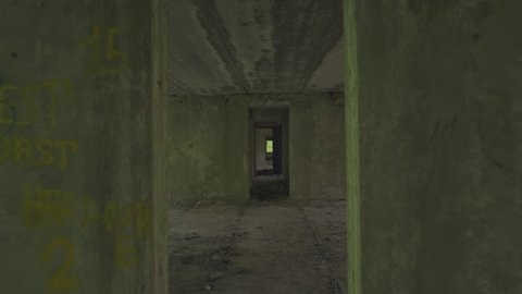 Walking down long corridor in abandoned building.
