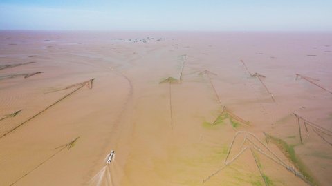 Aerial drone view of Tonle Sap. Fishing boat passing arrow headed fish traps heading to the horizon of this immense and largest fresh water lake in South East Asia.