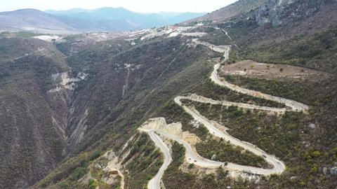 Aerial top down winding road country serpentine off-road, cinematic pattern line. countryside landscape, overcoming. Dramatic Mountain landscape with a river on the background in MExico