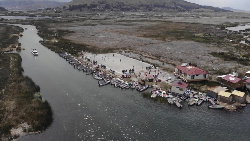 Aerial retreat from mid-day soccer game to Uros Floating Islands, Peru
