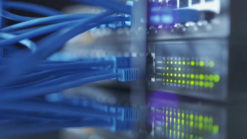 Close up fiber optic in server room. Network cables installed in the rack at data center. Ethernet cable on network switches background | Shutterstock HD Video #1073768828