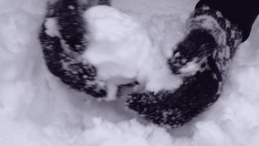 Close up of hands making a ball from snow. Wearing woven gloves with nordic pattern. Snow shaping video. High quality audio recording. ASMR style video and audio.
