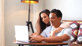 Young boy and girl together at home enjoying laptop computer sitting on the floor smiling and laughing - new life married people in love and relationship have fun watching online internet web