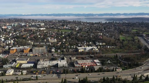 Cinematic aerial drone footage of Judkins Park, Atlantic, Leschi, I-90 freeway, Lake Washington, Mercer Island, commercial and residential buildings near downtown Seattle, Washington