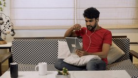 Smiling Asian businessman having video chat with clients,friends on tablet.Businessman happily talking on video call with friends using tablet at home office.Indian guy having video call and smiling.
