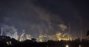 Timelapse of smoke and steam emitting from large industrial complex at night