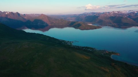 Aerial view of the Skaland village, high up from a mountain trail, during nightless night - tracking, drone shot