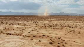 A desert sandstorm kicks up a dust devil in the Mojave Desert landscape - aerial view of the twister - Powered by Shutterstock - Get 15% off with code: PIKWIZARD15