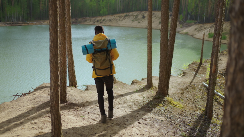 Back view of one black man looking on mountain and lake. Slow motion