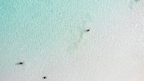People playing ball in the sea. People play water games in clear water on the beach. Aerial view