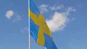 Swedish. National country flag on blue sky background. Flying fabric symbol. Tourism or travel summer day. international patriotic emblem. Nobody. Horizontal video
