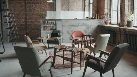 No people aerial shot of stylish loft workspace for business people and freelancers with designer chairs and wooden tables with gadgets and stationery on them