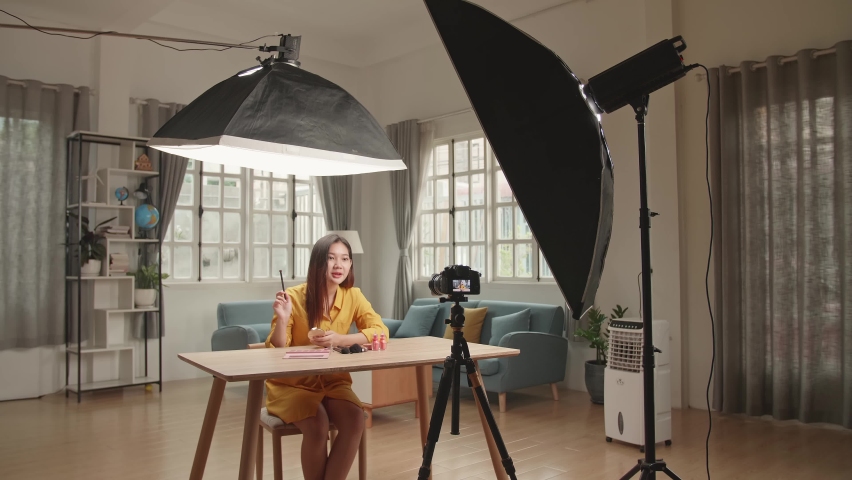 Beauty Blogger Woman Filming Daily Make-Up Routine Tutorial On Camera. Influencer Girl Live Streaming Cosmetics Product Review In Home Studio With Professional Lighting Equipment. Vlogger Job
 Royalty-Free Stock Footage #1073806448