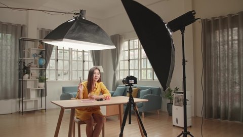 Beauty Blogger Woman Filming Daily Make-Up Routine Tutorial On Camera. Influencer Girl Live Streaming Cosmetics Product Review In Home Studio With Professional Lighting Equipment. Vlogger Job
