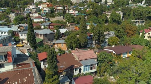 Aerail cinematic cityscape Yalta Crimea close-up village details. Old hotels houses mountainside. Real life population housing. Small courtyards, old Lada cars. Summer seaside resort Ukraine old town