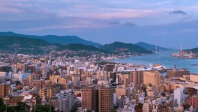 Nagasaki, Japan. Aerial timelapse made from a hill in Nagasaki, Japan, with a view over the entire center, including the bay and the hills. Cloudy and sunny day in summer, panning video