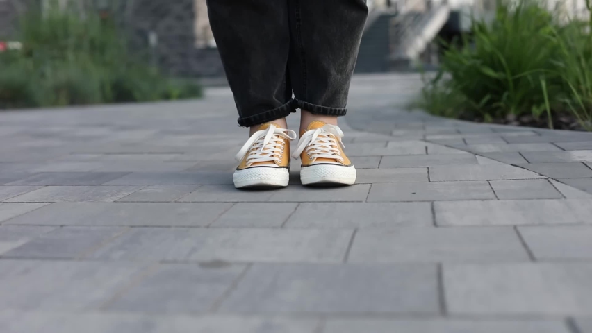 Close up Feet of woman while walking commuting to work. Female in yellow sneakers being walking down the street. Confident girl Feet Walking In City. Girl Legs In in shoes Walking on sidewalk.  Royalty-Free Stock Footage #1073826410