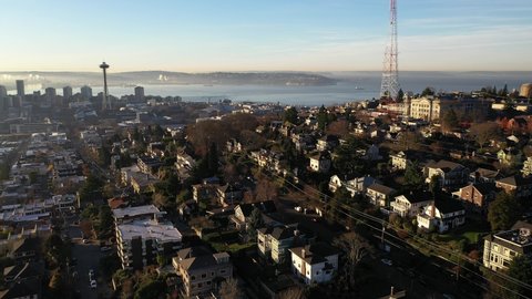 Cinematic sunrise aerial reveal footage of the Space needle, East Queen Anne, Queen Anne, Lower Queen Anne, Seattle Center, upscale neighborhoods uptown by Puget Sound, in Seattle, Washington