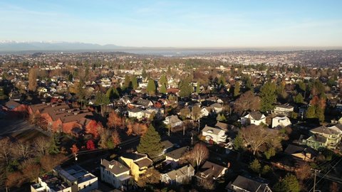 Cinematic tracking sunrise aerial view of West Queen Anne, Queen Anne, Lower Queen Anne, Kerry Park, upscale, affluent neighborhoods uptown by Puget Sound, in Seattle, Washington