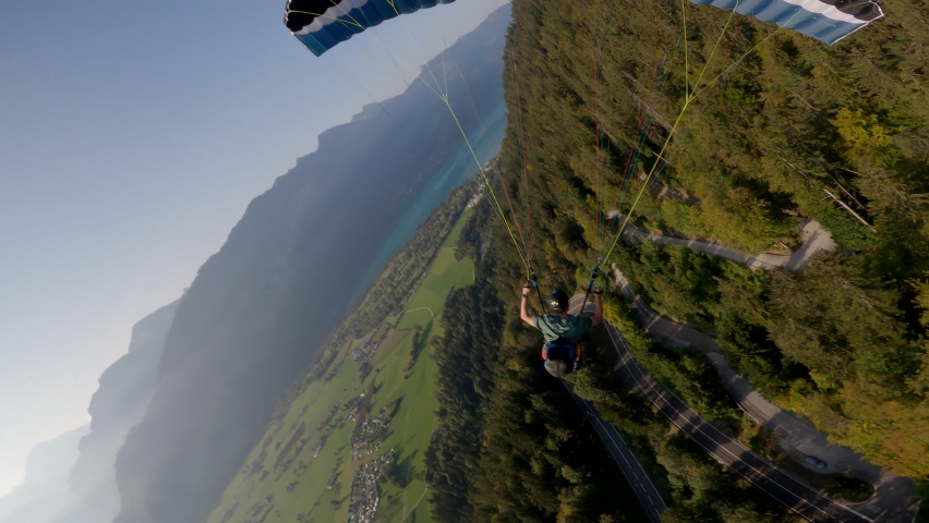 Man flying extreme paraglider in swiss alps, wide angle lens. Adventure freedom concept. | Shutterstock HD Video #1073848712