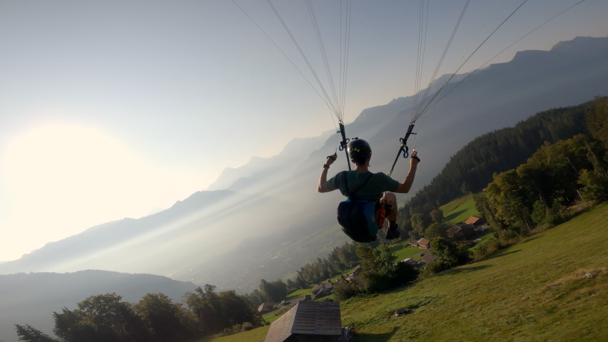 Man flying extreme paraglider in swiss alps, freedom concept. | Shutterstock HD Video #1073848715