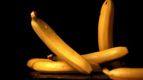 Super slow motion bananas fall on the table. On a black background. Filmed on a high-speed camera at 1000 fps. - Powered by Shutterstock - Get 15% off with code: PIKWIZARD15
